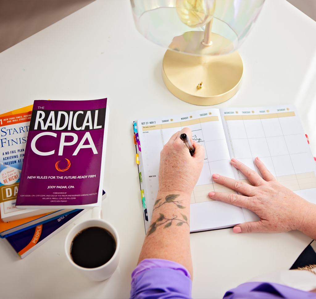 jackie compton, CPA writing in a planner next to the book "radical cpa"