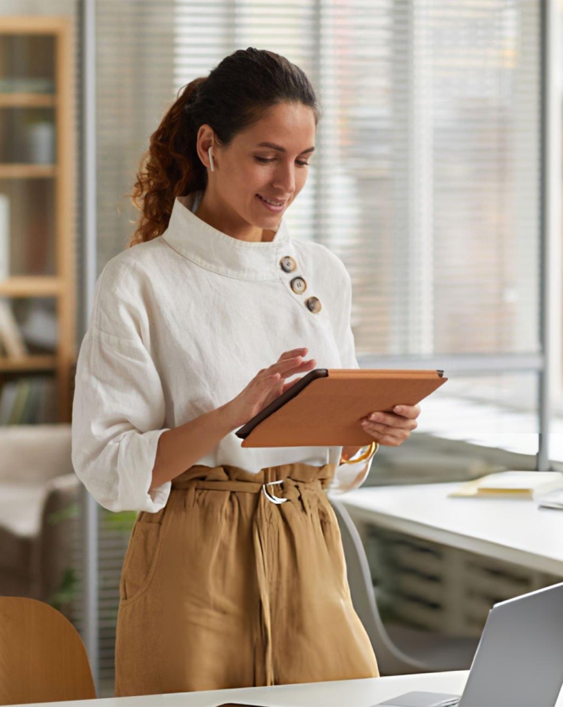 woman smiling typing on a tablet